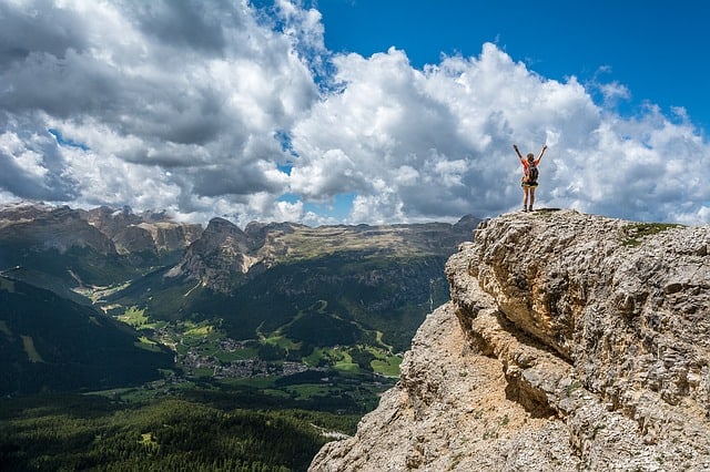 Man waving on top of a mountain